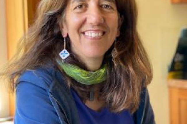 Sue DeBari's profile photo in a blue blouse and green scarf