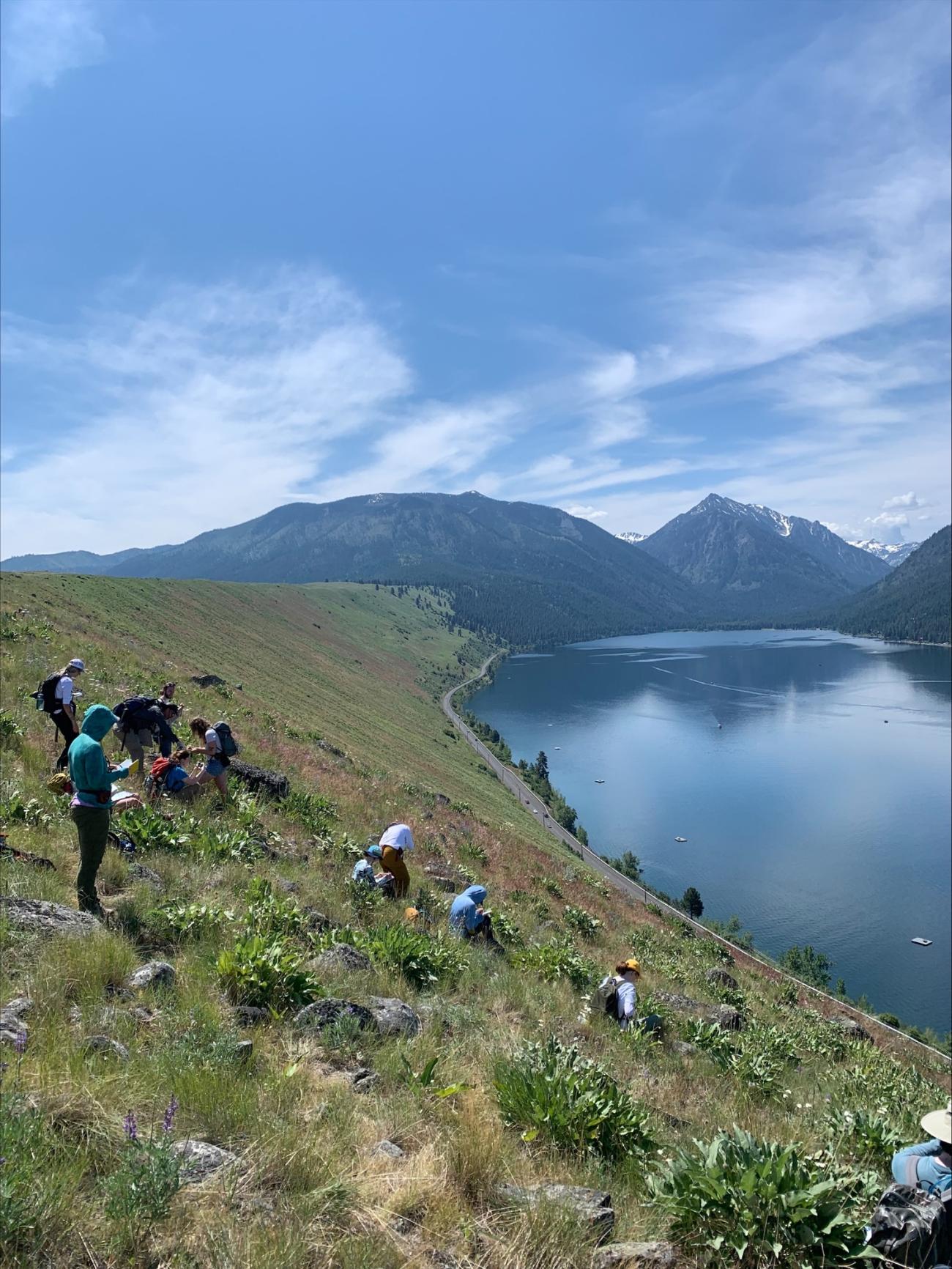 Students observing pristine blue lake and mountains